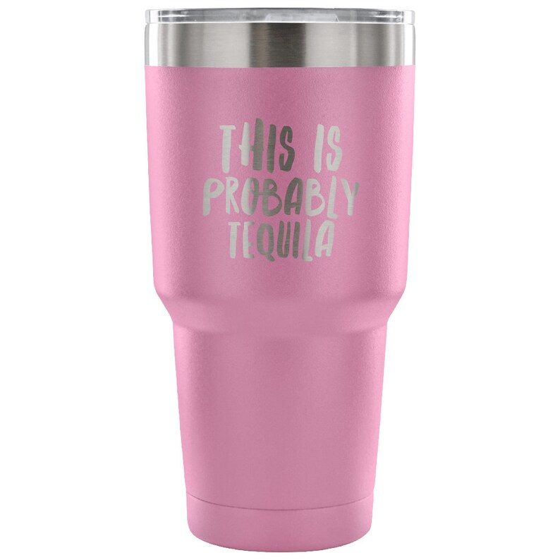 May include: Pink stainless steel tumbler with a white inscription that reads "This is probably tequila".