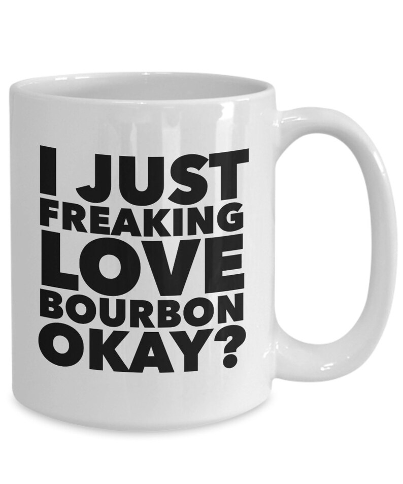 Pu&ograve; includere: Tazza in ceramica bianca con manico curvo. La tazza presenta il testo "I JUST FREAKING LOVE BOURBON OKAY?" in grassetto nero. Progettata per bevande calde.