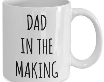 Puede incluir: Taza de café de cerámica blanca con texto negro que dice "Dad in the Making".