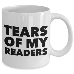 Könnte beinhalten: Eine weiße Keramik-Kaffeetasse mit schwarzem Text, der "Tears of my readers" lautet.