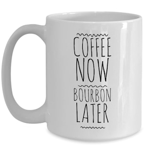 K&ouml;nnte beinhalten: Wei&szlig;e Keramik-Kaffeetasse mit schwarzem Text, der "Coffee Now Bourbon Later" lautet.