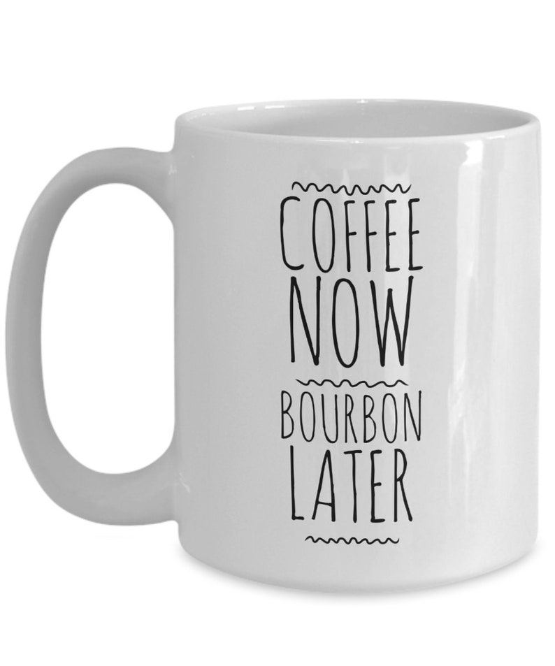 K&ouml;nnte beinhalten: Wei&szlig;e Keramik-Kaffeetasse mit schwarzem Text, der "Coffee Now Bourbon Later" lautet.