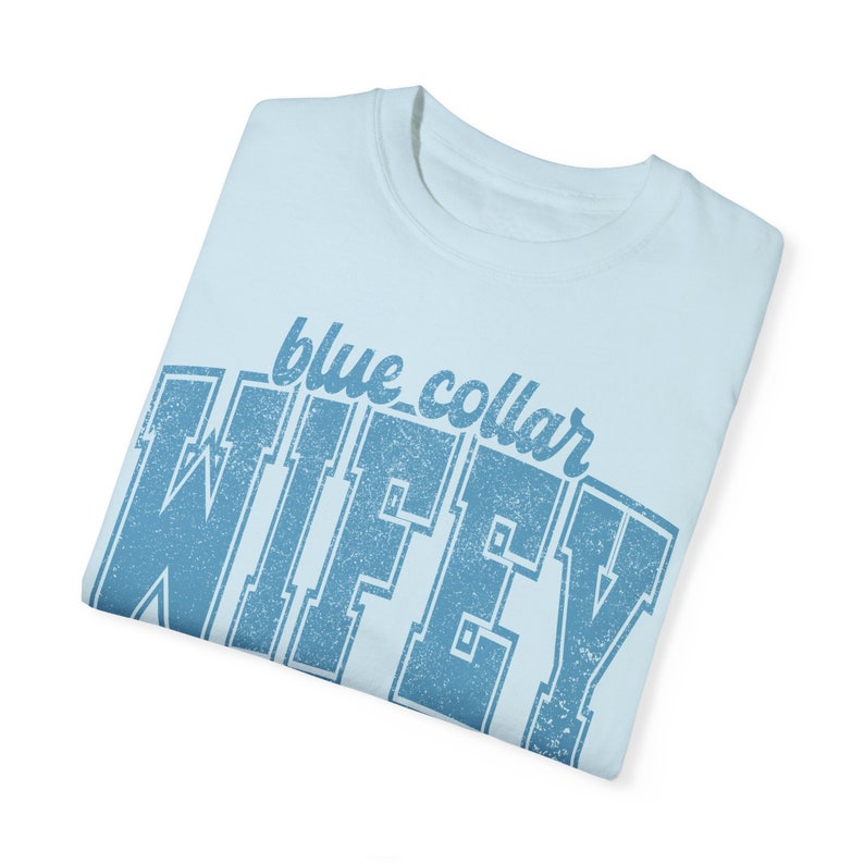 May include: Light blue t-shirt with a blue distressed graphic that says "blue collar wifey".