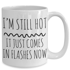 Puede incluir: Taza de caf&eacute; de cer&aacute;mica blanca con texto negro que dice "I'm still hot it just comes in flashes now".