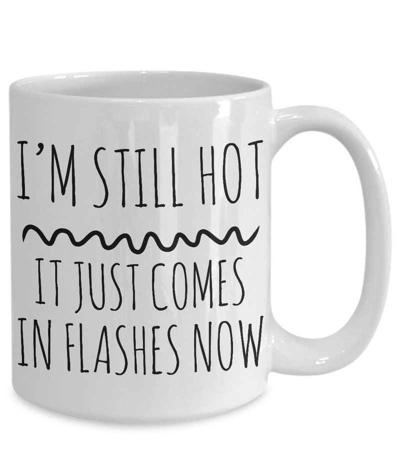 Puede incluir: Taza de caf&eacute; de cer&aacute;mica blanca con texto negro que dice "I'm still hot it just comes in flashes now".