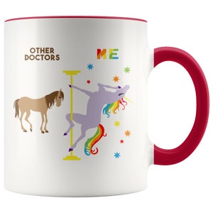 May include: White ceramic coffee mug with a red rim and handle. The mug features a graphic of a unicorn doing a pole dance with the text "OTHER DOCTORS" and "ME" on either side of the graphic.