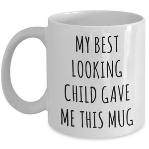 May include: White ceramic coffee mug with black text that reads "My best looking child gave me this mug."