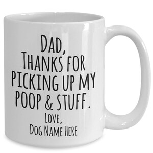 以下が含まれることがあります： 白いセラミック製のコーヒーカップで、黒い文字で「DAD, THANKS FOR PICKING UP MY POOP & STUFF. LOVE, DOG NAME HERE」と書かれています