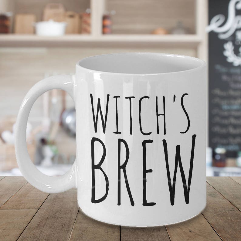 May include: White ceramic coffee mug with black text that reads "Witch's Brew".