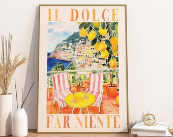 May include: A framed vertical art print featuring a watercolor illustration of a coastal Italian terrace with two striped chairs, a yellow table with two orange cocktails, and lemon trees, with the text IL DOLCE FAR NIENTE printed in orange.