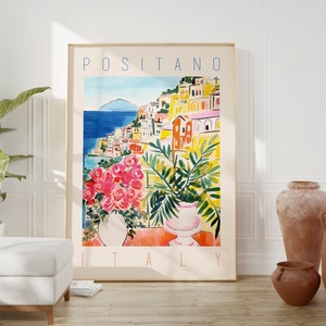 Może przedstawiać: Kolorowy plakat z tekstem "POSITANO WŁOCHY" w niebieskich literach. Plakat przedstawia akwarelę przedstawiającą nadmorskie miasto z kolorowymi budynkami i błękitnym oceanem.