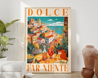 May include: A vintage-style poster with the text "DOLCE FAR NIENTE" in orange and white. The poster features an illustration of a colorful Italian village overlooking a blue sea with boats. There are glasses of orange drinks and oranges on a table in the foreground.