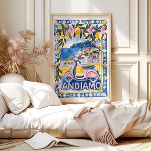 May include: A colorful illustration of a pink scooter with a cityscape in the background. The text "ANDIAMO" is written below the scooter. The illustration is framed and hanging on a wall in a room with a white couch and a throw blanket.