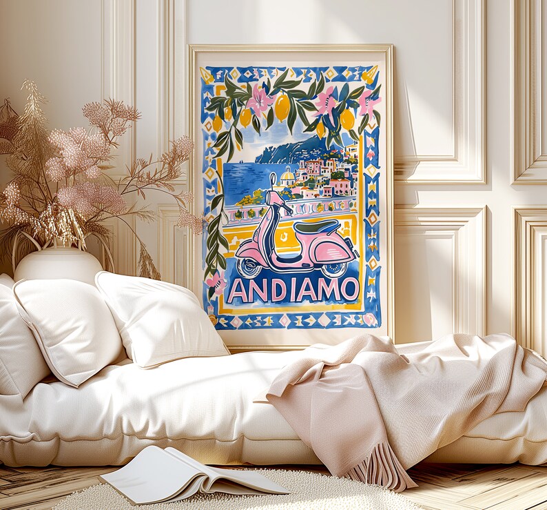 May include: A colorful illustration of a pink scooter with a cityscape in the background. The text "ANDIAMO" is written below the scooter. The illustration is framed and hanging on a wall in a room with a white couch and a throw blanket.