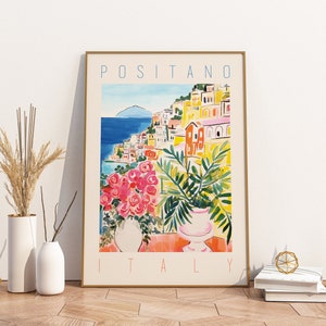 Może przedstawiać: Kolorowy plakat z akwarelową ilustracją Positano we Włoszech. Plakat przedstawia widok kolorowych budynk&oacute;w miasta, błękitnego morza i zielonej rośliny w doniczce. Tekst "Positano, Włochy" jest wydrukowany na kremowym tle białym kolorem.