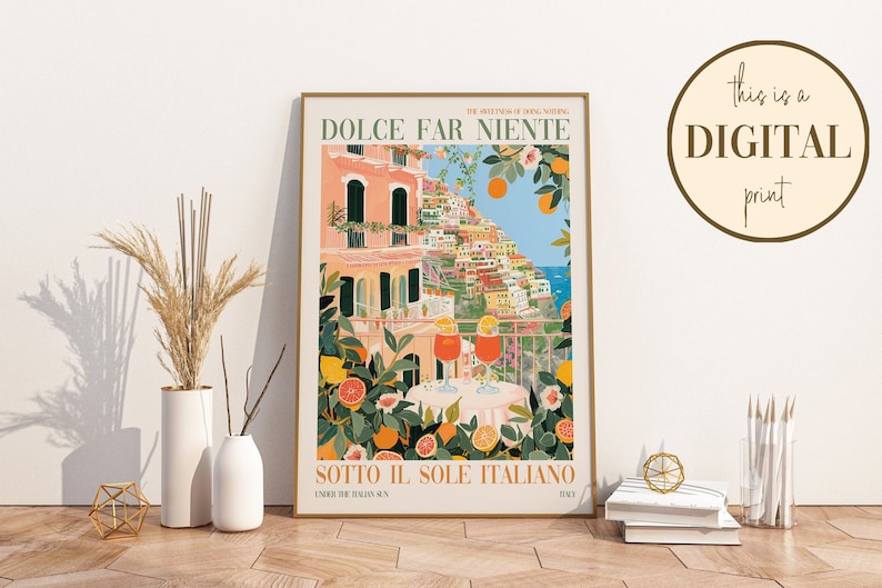 Op de afbeelding: Een kleurrijke illustratie van een stadsbeeld met gebouwen, bloemen en twee glazen sinaasappelsap. De tekst "DOLCE FAR NIENTE" en "SOTTO IL SOLE ITALIANO" staat op de poster gedrukt. De tekst "Dit is een DIGITALE print" staat op een cirkel in de rechterbovenhoek van de afbeelding.