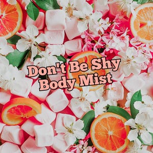 Puede incluir: Imagen vibrante con el texto "Don't Be Shy Body Mist" en rosa y negro. El fondo es una mezcla de rodajas de naranja, flores blancas, hojas verdes y malvaviscos rosas, creando una estética fresca y floral. Anuncio de bruma corporal.