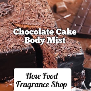 Puede incluir: Una porción de pastel de chocolate oscuro con virutas de chocolate. El texto "Chocolate Cake Body Mist" y "Nose Food Fragrance Shop" es visible. El pastel tiene un glaseado brillante.