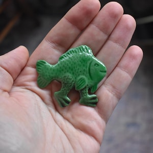 Imán de nevera con diseño de pez verde caminando, arte popular medieval, manuscrito iluminado hecho a mano.