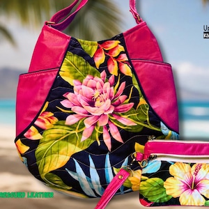 May include: A pink and floral tote bag and matching wristlet. The tote bag has a large floral design with pink, yellow, and green accents. The wristlet features a similar floral pattern. The bags are made with rescued leather.