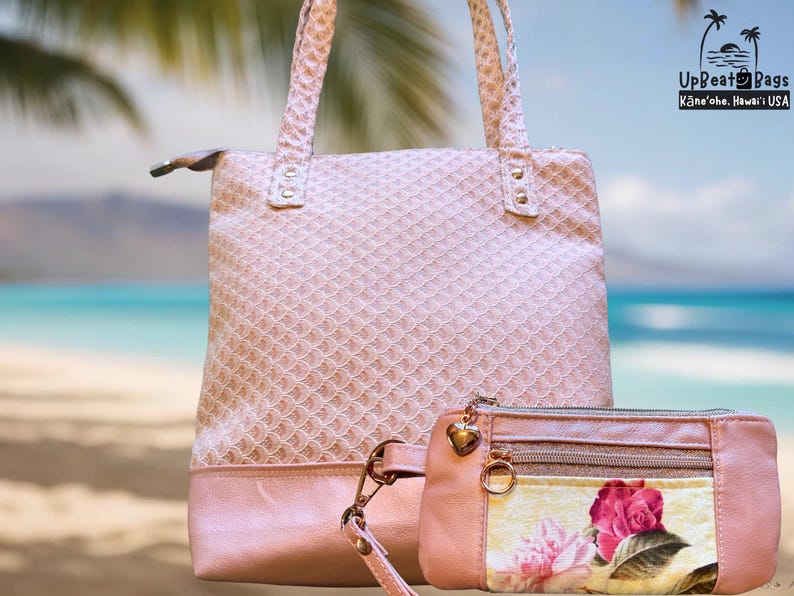 Puede incluir: Un bolso tote rosa claro y un clutch a juego. El bolso tote tiene un patr&oacute;n texturizado y una base rosa s&oacute;lida. El clutch presenta un dise&ntilde;o floral con una rosa rosa y una cremallera dorada. Los bolsos est&aacute;n sobre un fondo de playa.
