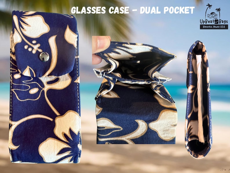 May include: A navy blue glasses case with a dual pocket design. The case features a floral pattern in white and tan. The case is shown in three views: closed, open, and side view. The text "GLASSES CASE - DUAL POCKET" is at the top.