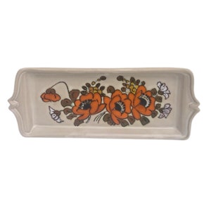 Könnte beinhalten: Ein rechteckiges Serviertablett aus Keramik mit Blumenmuster. Das Tablett ist beige mit einem Rand aus orangefarbenen, braunen und weißen Blumen.
