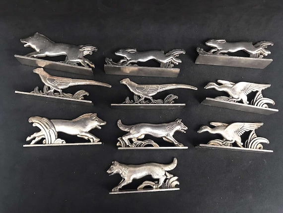 SUITE DE 12 PORTE COUTEAUX " dragon chinois " EN METAL ARGENTE CHROME