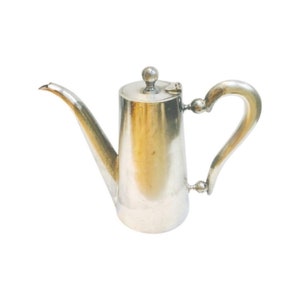 May include: A silver teapot with a rounded body and a curved handle. The teapot has a polished finish and a small knob on the lid.