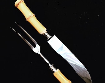 May include: A set of bamboo handled serving utensils, a knife and a fork, with silver blades.