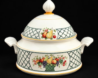 Peut inclure: Une soupière en céramique blanche avec un couvercle assorti, ornée d'un motif en treillis vert foncé et d'une illustration de fruits colorés. Elle possède deux anses latérales et un bouton décoratif sur le couvercle, bordé de lignes jaunes.