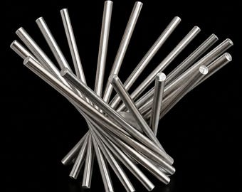 May include: A silver-colored metal fruit bowl constructed from numerous thin, cylindrical rods arranged in a spiraling, fan-like pattern. The rods radiate outward from a central base, creating an open, cage-like structure with a wide, circular top.