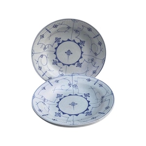 Peut inclure: Trois assiettes en céramique blanche avec des motifs floraux bleus. Les assiettes sont empilées les unes sur les autres.