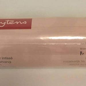 May include: A roll of Heytens wallpaper with a white and beige pattern. The label reads "papier peint intiss&eacute; unwoven behang" and "pose facile" with instructions for hanging. The roll is 53 cm x 10.05 m.