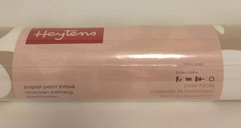 May include: A roll of Heytens wallpaper with a white and beige pattern. The label reads "papier peint intiss&eacute; unwoven behang" and "pose facile" with instructions for hanging. The roll is 53 cm x 10.05 m.