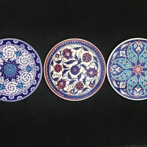 Peut inclure: Trois assiettes rondes en céramique avec des motifs floraux bleus et blancs. Les assiettes ont un fond blanc avec des motifs floraux bleus et rouges.