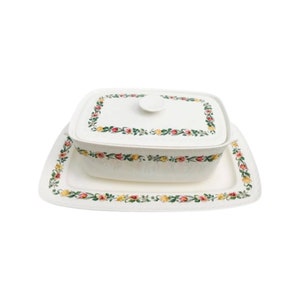 Peut inclure: Un plat de service rectangulaire blanc avec un couvercle et un plateau assorti. Le plat et le plateau sont décorés d'un motif floral de fleurs rouges, jaunes et roses. Le couvercle a une petite poignée ronde.