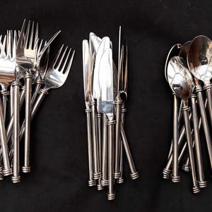 Puede incluir: Un juego de cubiertos con mangos plateados y acabado pulido. El juego incluye tenedores, cuchillos y cucharas.