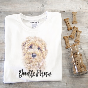 May include: White t-shirt with a doodle dog illustration and the text "Doodle Mom" printed on the front.