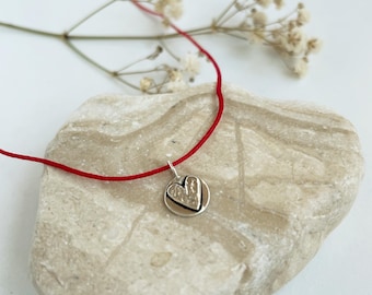 handmade sterling silver heart pendant on a red string, adjustable