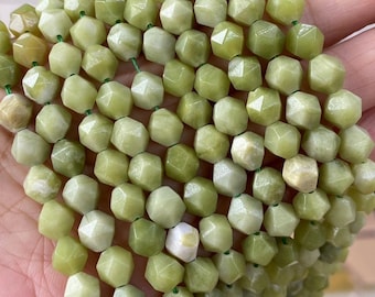 May include: A strand of light green jade beads, each bead is faceted and has a slightly irregular shape. The beads are strung on a thin green thread.