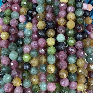 Peut inclure: Des rangées de perles de pierres précieuses à facettes de différentes couleurs, notamment vert, violet, jaune et noir. Les perles rondes ont une surface polie et réfléchissante. Idéal pour la création de bijoux.