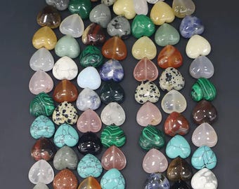 May include: A collection of heart-shaped gemstones in various colors, including green, pink, blue, and brown. The gemstones are arranged closely together, creating a visually appealing display. The stones have a polished, smooth surface.