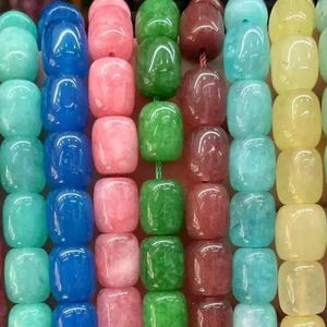 May include: A collection of smooth, polished, barrel-shaped beads arranged in vertical strands. The beads feature a diverse palette of colours including light pink, deep red, turquoise, bright blue, soft pink, vibrant green, maroon, aqua, yellow, pale green, and white.