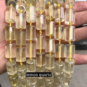 May include: A strand of lemon quartz beads, each bead is faceted and has a rectangular shape. The beads are strung on a yellow thread.
