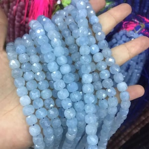 Puede incluir: Cadenas de cuentas facetadas de aguamarina azul claro. Las cuentas son de un color azul pálido y tienen una forma ligeramente irregular. Están ensartadas, creando una apariencia fluida y texturizada. Las cuentas son una opción popular para la fabricación de joyas.