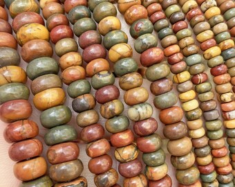 May include: A strand of multi-colored gemstone beads. The beads are round and have a mottled pattern of brown, red, green, and yellow. The beads are strung on a clear thread.