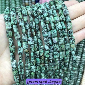 May include: A strand of green and black jasper beads. The beads are rectangular and have a speckled pattern. The beads are strung on a string and are ready to be used for jewellery making.