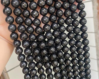 May include: A collection of black, spherical beads with a shiny surface. The beads are strung together, creating multiple strands. The beads are consistent in size and shape, with a smooth, polished look. These beads are likely intended for jewellery making.