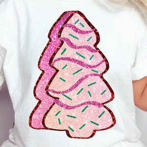 May include: A pink and white glittery Christmas tree cookie with green sprinkles.